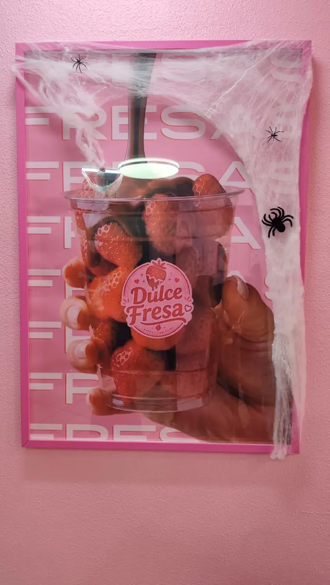 Cuadro de un vaso de fresas con chocolate en la pared